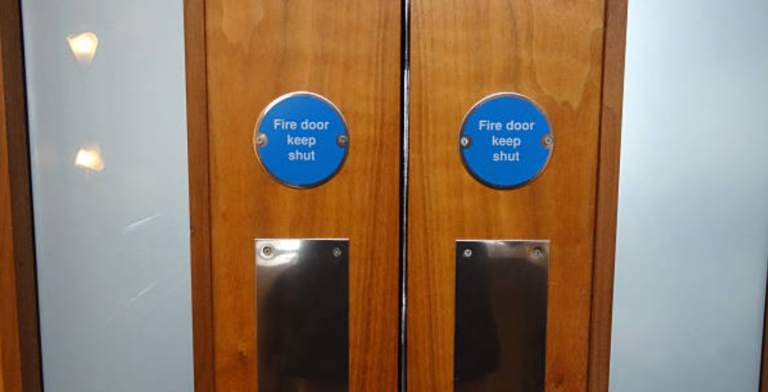 Fire door inspection - Phoenix STS inspector checking fire door seals, hinges, and certification label