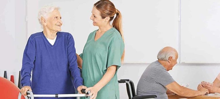 People Moving & Handling Course Ireland - Healthcare worker assisting elderly resident with safe transfer from bed to wheelchair in nursing home setting