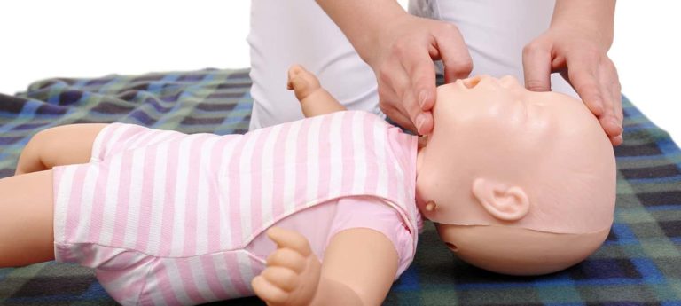 Instructor demonstrating infant airway management technique on a baby training manikin during a Paediatric First Aid Course from Phoenix STS Ireland